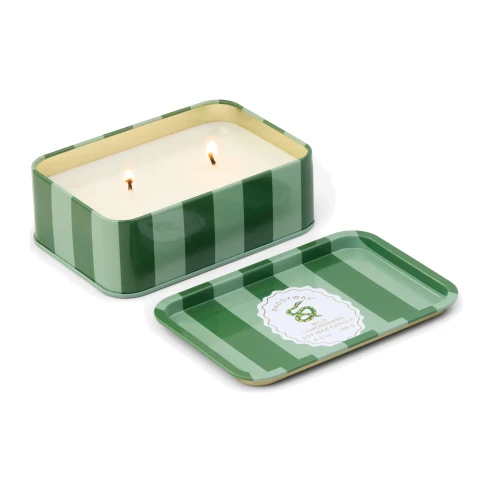 Vela Paddywax A Dopo Wild Lemongrass encendida con dos mechas y su tapa metálica a rayas verdes