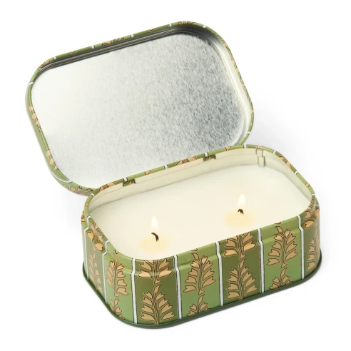 Vela Paddywax Cherie Smoked Pistachio abierta, con sus dos mechas encendidas y la tapa con bisagra levantada