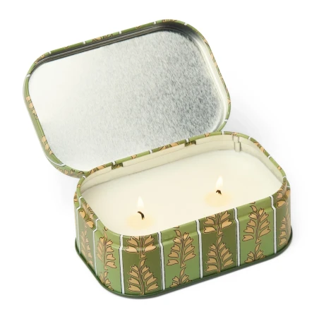 Vela Paddywax Cherie Smoked Pistachio abierta, con sus dos mechas encendidas y la tapa con bisagra levantada