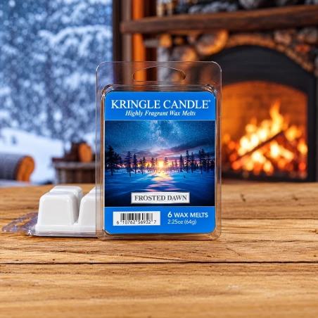 Wax melts Kringle Candle Frosted Dawn 64 g sobre una mesa de madera junto a la chimenea en un ambiente invernal