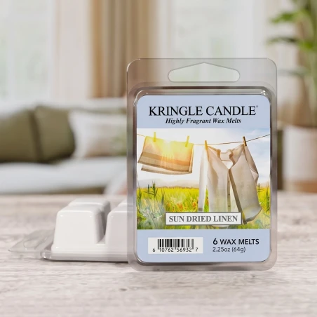 Wax melts Kringle Candle Sun Dried Linen 64 g sobre una mesa de madera clara en un salón luminoso y primaveral