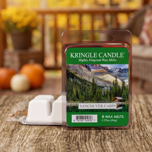 Wax melts Kringle Candle Vancouver Cabin 64 g sobre una mesa de madera rústica en el porche de una cabaña en otoño
