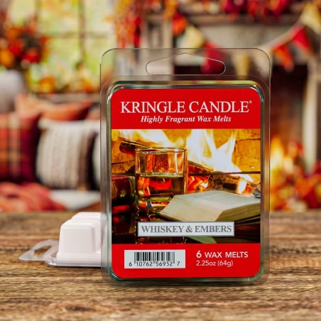 Wax melts Kringle Candle Whiskey & Embers 64 g sobre una mesa de madera en un salón otoñal junto a la chimenea
