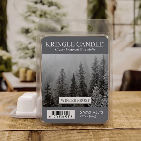 Wax melts Kringle Candle Winter Frost 64 g sobre una mesa de madera en un ambiente invernal con abetos nevados