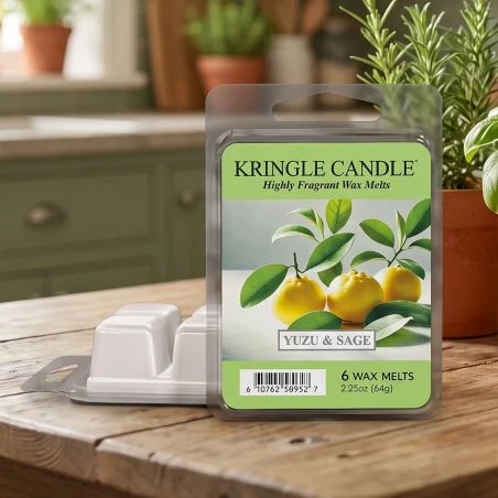 Wax melts Kringle Candle Yuzu & Sage 64 g sobre una mesa de madera en una cocina luminosa con hierbas frescas