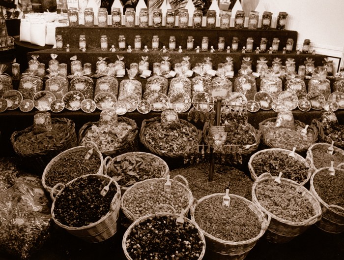 Cestas de mimbre con pot-pourri a granel y tarros en un stand de Boles d'olor